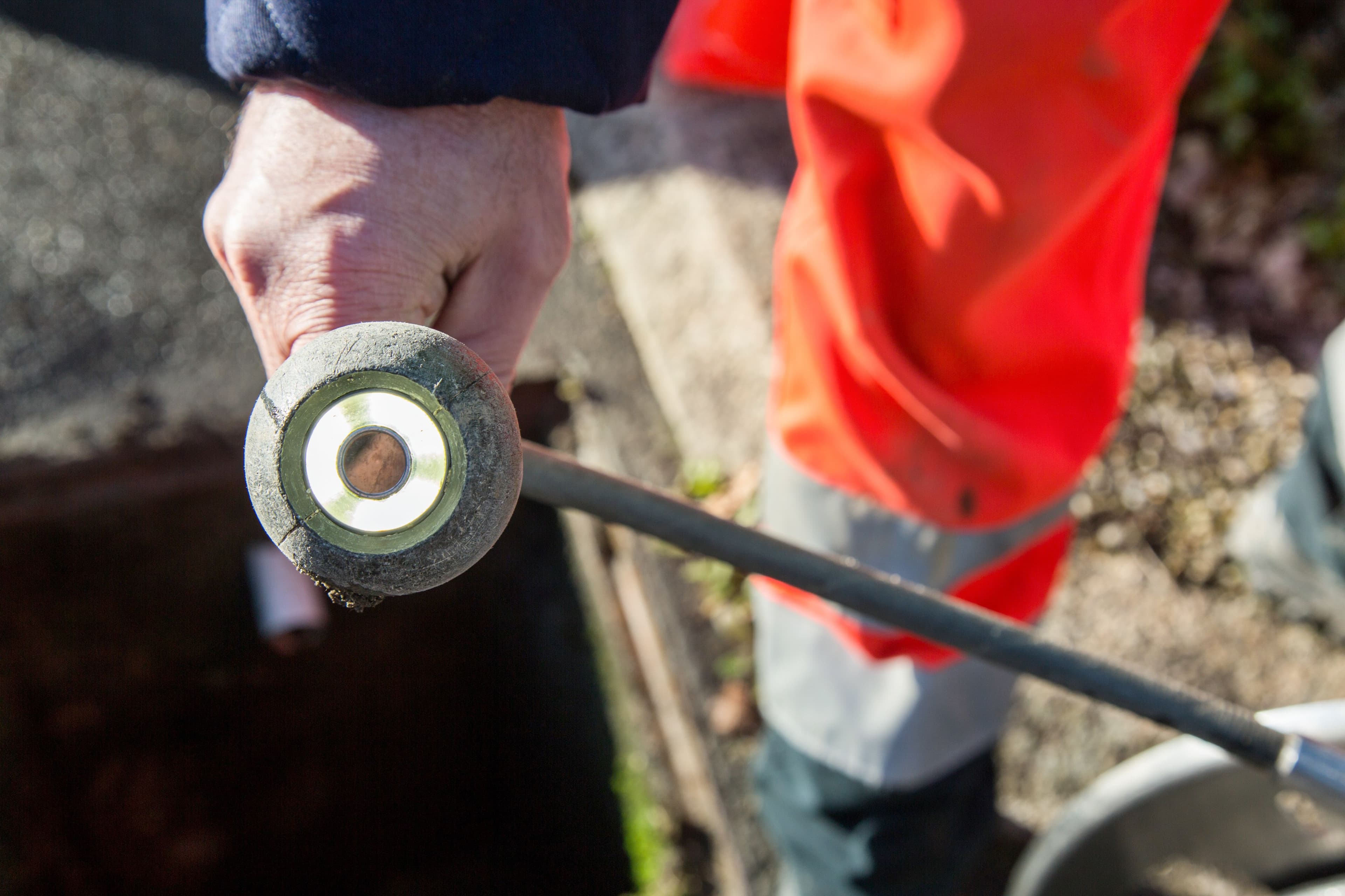 Technicien ABL en phase de diagnostic réseau, buse de curage haute pression à la main