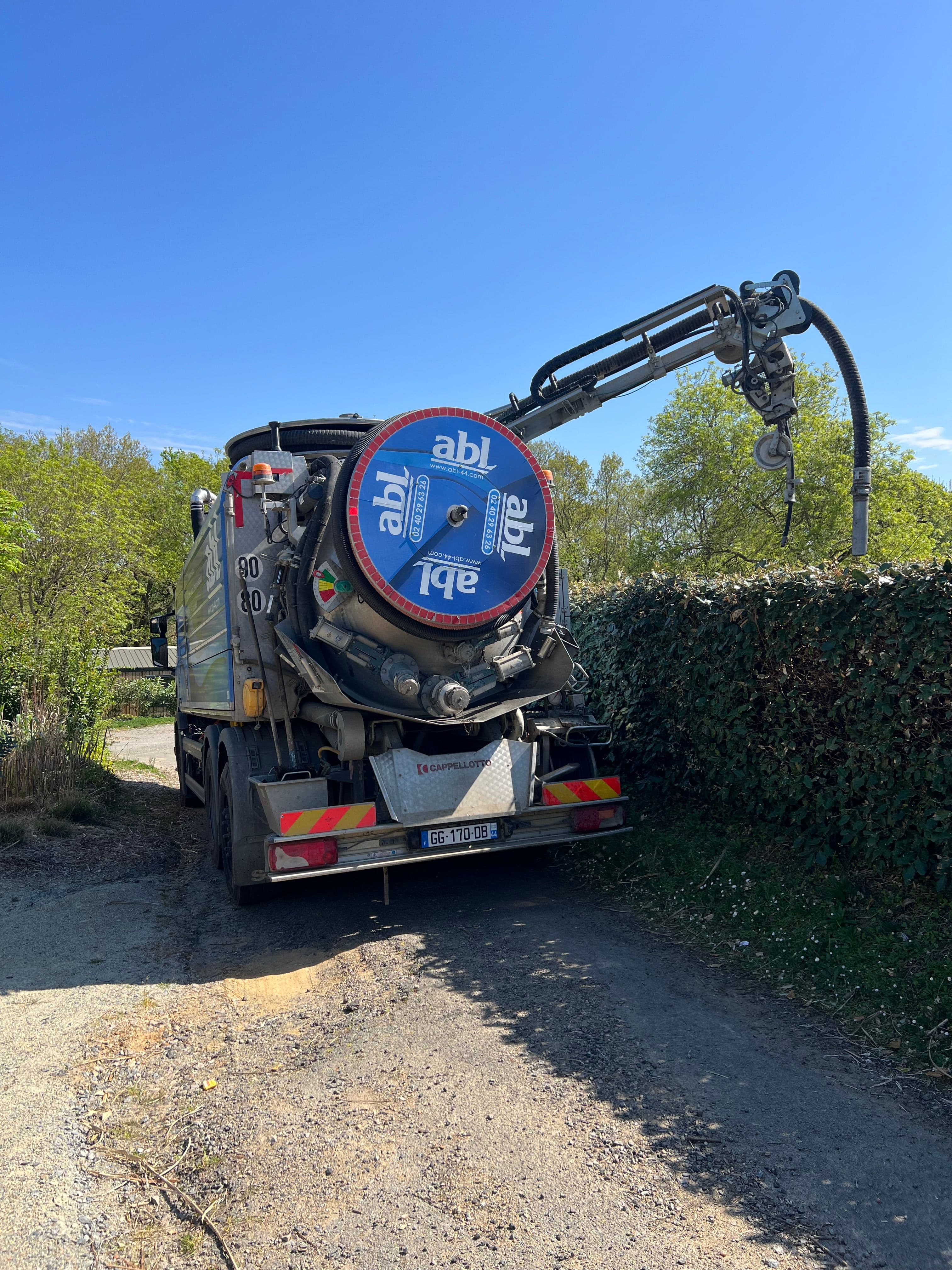 Camion ABL Assainissement effectuant le pompage d’une fosse avec potence dans une zone rurale de Loire-Atlantique